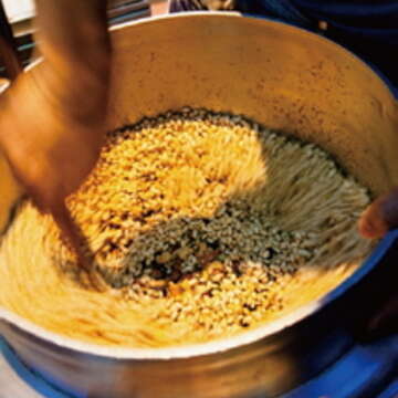 米粒膨發完成後，加入麥芽糖及果仁、花生等材料攪拌，動作要快又準，以免米香凝結成硬塊。（攝影／顏涵正）