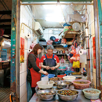 新富市場的鹹蜆仔專賣店在傳統市場裡很少見，受到許多外籍旅客的喜愛。（攝影／林煒凱）