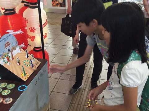 觀光客開心參與臺北夜市套圈圈遊戲，喜獲臺北紀念品。