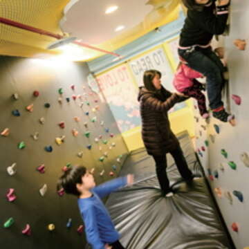 與孩子一同在中山親子館的兒童攀岩場爬高玩樂，可訓練四肢的協調性。（許斌攝）