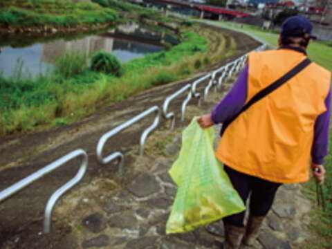 每當步入河濱公園，一支夾子、一個袋子，陳玉枝總是把垃圾清理乾淨。（攝影／許斌）
