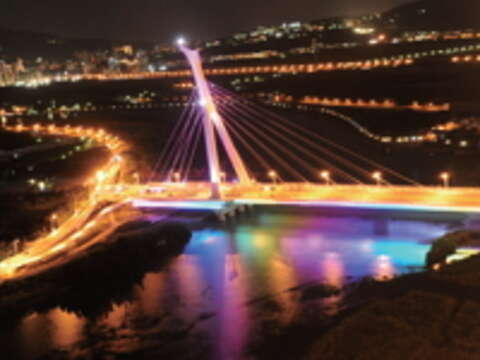 夜幕低垂時，社子大橋光彩奪目景觀照明，為臺北夜空帶來繽紛色彩。（攝影／劉佳雯）