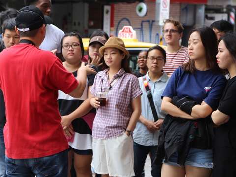 外籍旅客專注聆聽導覽解說士林典故