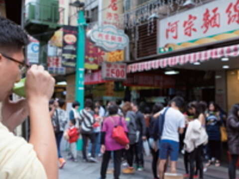 一群人旁若無人的站著吃麵線,成為西門町的另類奇景。(攝影/楊智仁)