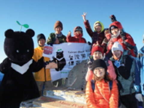 台灣黑熊保育協會志工背著黑寶偶裝登上玉山回娘家，受到登山客熱烈歡迎。（圖／台灣黑熊保育協會提供）