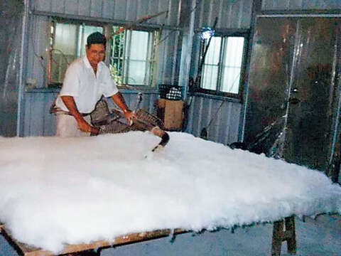 1990年代師傅手工打棉被的景況。（圖／瑞成手工棉被店提供）