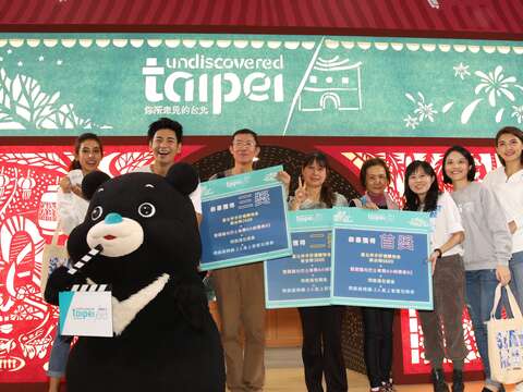 台北國際旅展臺北館造勢大放送，熊讚、觀光傳播局副局長陳譽馨、食尚達人楊子儀、紙雕藝術家成若涵、熊讚與獲獎民眾開心合影。.JPG