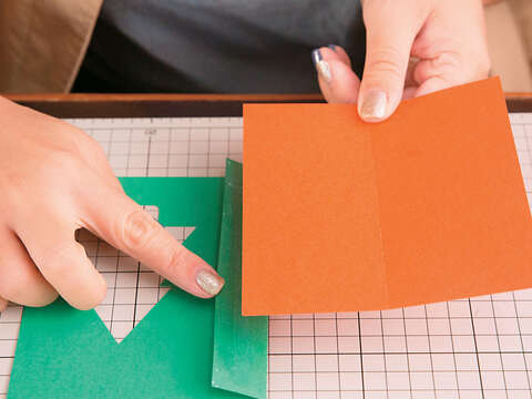 Step2 將橘紅色美術紙對摺，綠色美術紙左邊內摺2.5cm。（攝影／賴智揚）