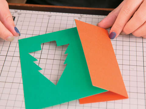Step3 在綠色美術紙內摺的地方黏貼上對摺的橘紅色美術紙，並將橘紅色美術紙往後摺，夾住綠色美術紙。（攝影／賴智揚）