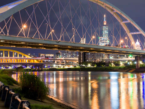 以101大樓及台北城市閃爍的燈光為背景，搭配上倒映在河面的橋景，也是令人炫目的構圖