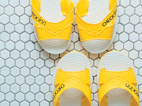 房內的拖鞋將傳統藍白拖改造為年輕活力的黃白設計。（圖／CHECK inn雀客旅館提供）