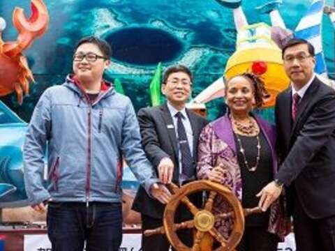 外交部、大使館與臺北市政府共同為「潛進大藍洞，探索貝里斯」轉動船舵。