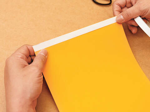 Step 1  沿著紙張邊緣在色紙短邊黏上雙面膠。（攝影／林俊耀）