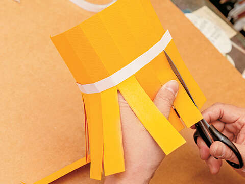 Step 8	將紙張翻面，從對摺處沿著Step7摺出的7條摺線往雙面膠的方向剪，剪到雙面膠處即停止。