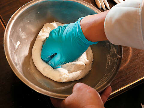 Step4將大塊的麵糰挖一個小洞，放入煮過的小麵糰，再用手由外而內壓摺搓揉。（攝影／林俊耀）