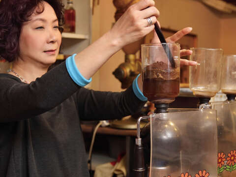 經營咖啡店三十餘年的老闆娘余麗蘋，至今持續為熟客烹煮咖啡，保留記憶中的味道。（圖／Hally Chen提供）