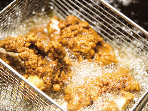 看板メニューの豚のから揚げは、食べやすいように骨を露出させるなどの工夫がされています。カリッと揚がった衣は国内外問わず多くの人に支持されています。