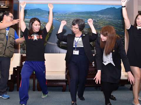郭婞淳向世大運執行長蘇麗瓊、觀傳局長簡余晏示範舉重標準動作