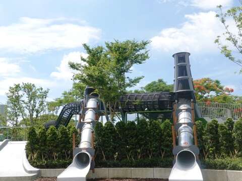 華山大草原遊戲場-煙囪遊戲塔，造型發想自華山酒廠的大煙囪，融和於山坡地景綠樹之中