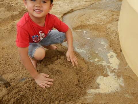 小朋友用水與沙築出小水道，享受挖掘的樂趣