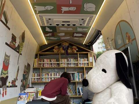 滿滿的好書放滿書架，還有娃娃和可愛動物伴讀，北市圖行動書車陪您打造夢想中的閱讀空間