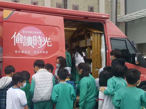 「行動書車前進校園場次」─小朋友圍在書車旁挑選圖書，對閱讀的熱忱一覽無遺