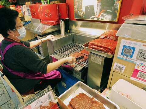 金龍肉乾創始店老闆娘白玉嬌半世紀以來堅守崗位，在攤位前為客人烤出一片片令人驚艷的好吃肉乾