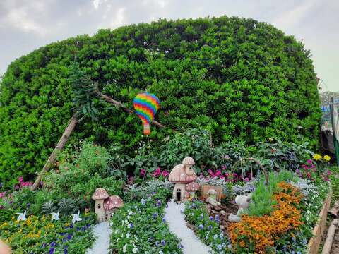 玫瑰園志工極具巧思利用童趣的熱氣球和蘑菇屋妝點園圃。