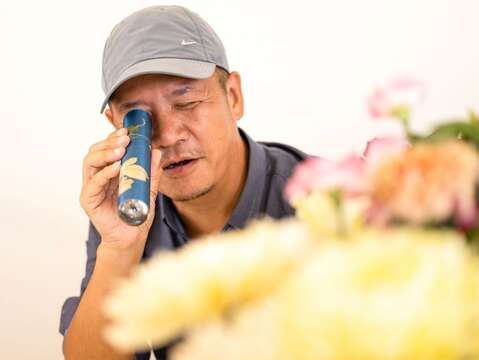 設計師蕭青陽拿起萬花筒，觀察萬花筒裡的花花世界