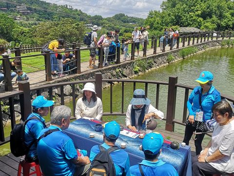 民眾於彩雲亭喝茶，享受貓空山林水景風光。