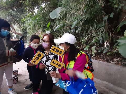 宣導團隊向前來天母公園的親子宣導遇獼猴的三不原則