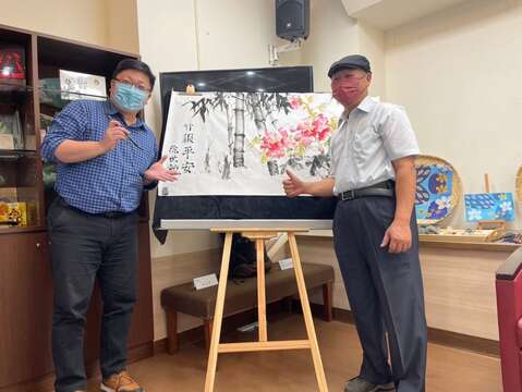 成果發表會開幕演出由北市客委會主委徐世勲在畫作上題字寓意平安(圖片來源：臺北市政府客家事務委員會)
