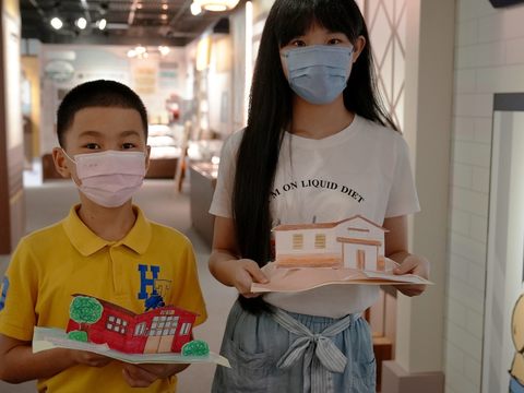 西松國小六年級賴妤蓁(右)和東園國小五年級高唯恪(左)展示立體老房子卡片.JPG(圖片來源：台北市政府觀光傳播局)