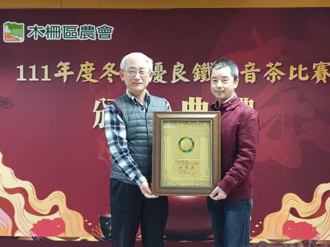 臺北市政府產業發展局王三中局長頒發市府獎牌予冬茶特等獎得主張農林(圖片來源:臺北市政府產業發展局)