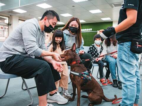 「台灣心輔犬培育團隊」技術長鍾皓羽示範,如何正確地與狗狗進行第一次接觸,建立良好的雙向關係。(攝影/鄒保祥)