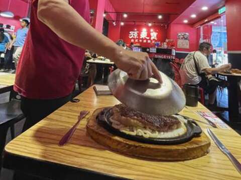 The sizzling hot steam and crackling sound that accompany the removal of the cover are distinctive features of Taiwanese steak.