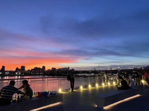 公園內跨堤景觀平臺觀賞夕陽餘暉民眾(圖片來源：臺北市政府工務局衛生下水道工程處)