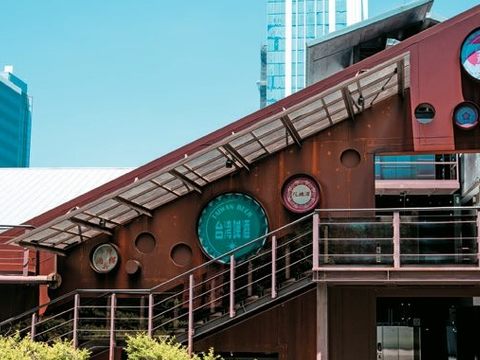 「瓶蓋工廠台北製造所」的鋼構主牆面，以裝飾巨大的瓶蓋突顯此處的歷史。(圖片來源：臺北市政府觀光傳播局)