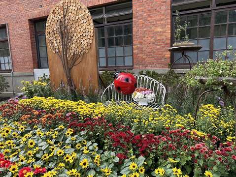 以修剪後之枝條手工製作樹木及公園園椅搭配菊科花卉營造「菊之境 秋之家」(圖片來源：臺北市政府工務局公園路燈工程管理處)