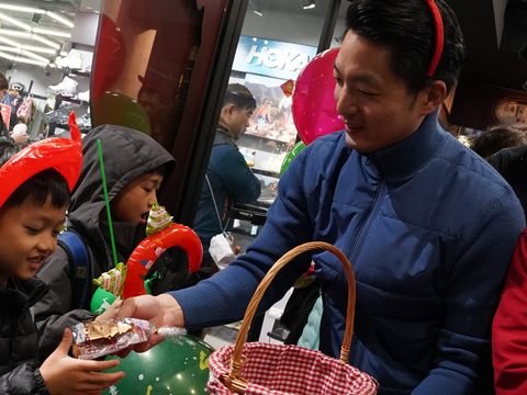 蔣市長與健走隊伍沿路發放耶誕禮物予小朋友。(圖片來源:臺北市政府觀光傳播局)
