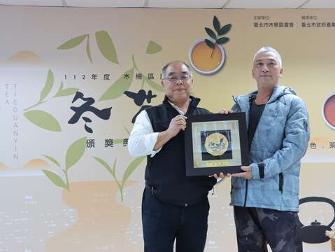 臺北市政府產業局劉永修簡任技正頒發市府獎牌予112年木柵冬茶特等獎得主。(圖片來源：臺北市政府產業發展局)