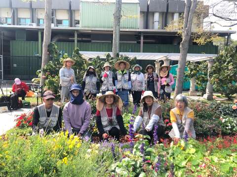 志工與同仁一同養護園藝植物佈展區合影。(圖片來源：臺北市政府工務局公園路燈工程管理處)