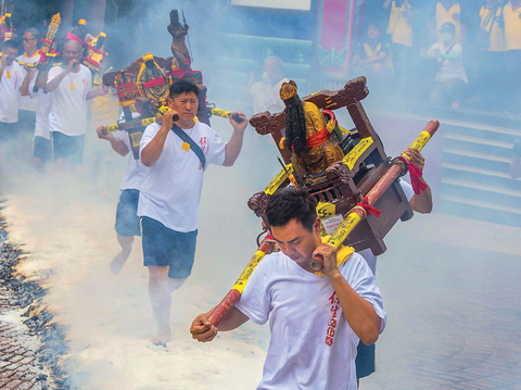 力士們扛著神像赤腳走過火炭，完成「過火」儀式。