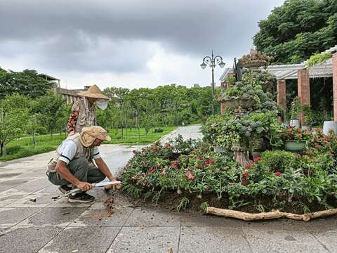 志工夥伴利用回收木材做收邊。(圖片來源：臺北市政府工務局公園路燈工程管理處)