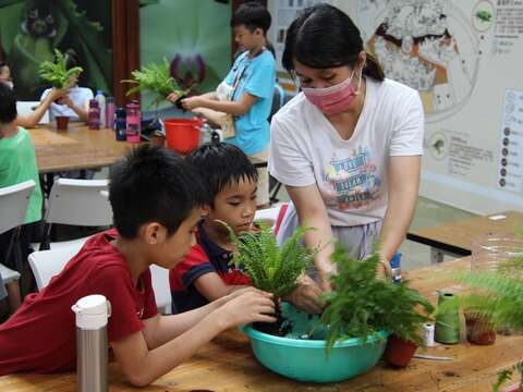 非常認真學習捏水苔球的方法。(圖片來源：臺北市政府工務局公園路燈工程管理處)