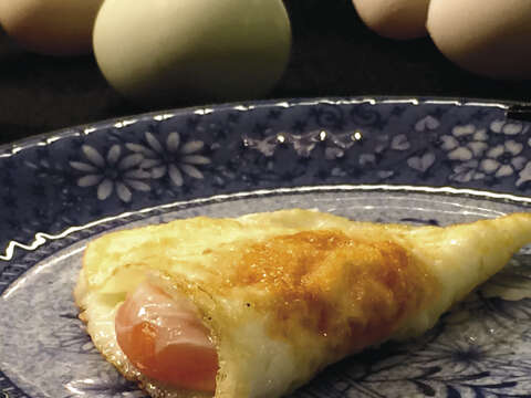 半月形的荷包蛋煎至七分熟，蛋黃橙亮飽滿著熱情，可獨食，更宜搭配米飯或麵條。（圖／焦桐提供）