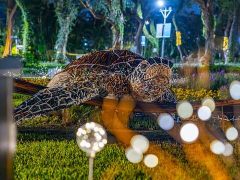 「攏來看菊」展區，透過夜晚燈飾的襯托下，佇立著大型恐龍，與澳洲植物相呼應，栩栩如生彷彿就走進侏儸紀(圖片來源：臺北市政府工務局公園路燈工程管理處)