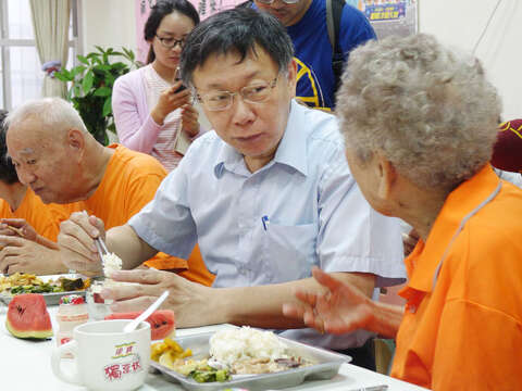 市長柯文哲前往社區老人據點與長者一起共餐、話家常。(圖/中央社提供)