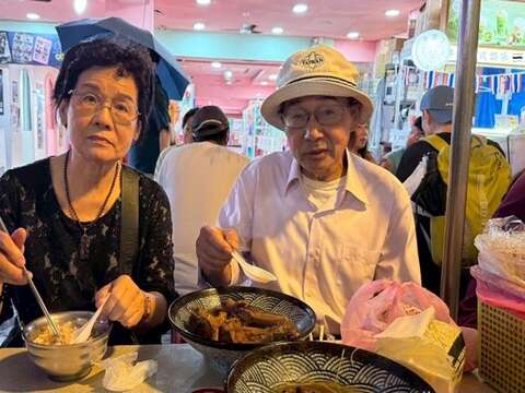 「陳董藥燉排骨」濃郁的中藥湯頭熬煮數小時,排骨燉得軟嫩入味,令黃炳輝(右)覺得相當療癒身心(圖片來源:臺北市市場處)