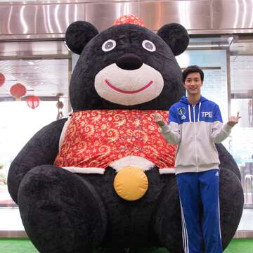 桌球選手江宏傑參觀台北探索館 「站上起跑點」特展,與超大熊讚合影。(圖/2017臺北世大運執委會提供)